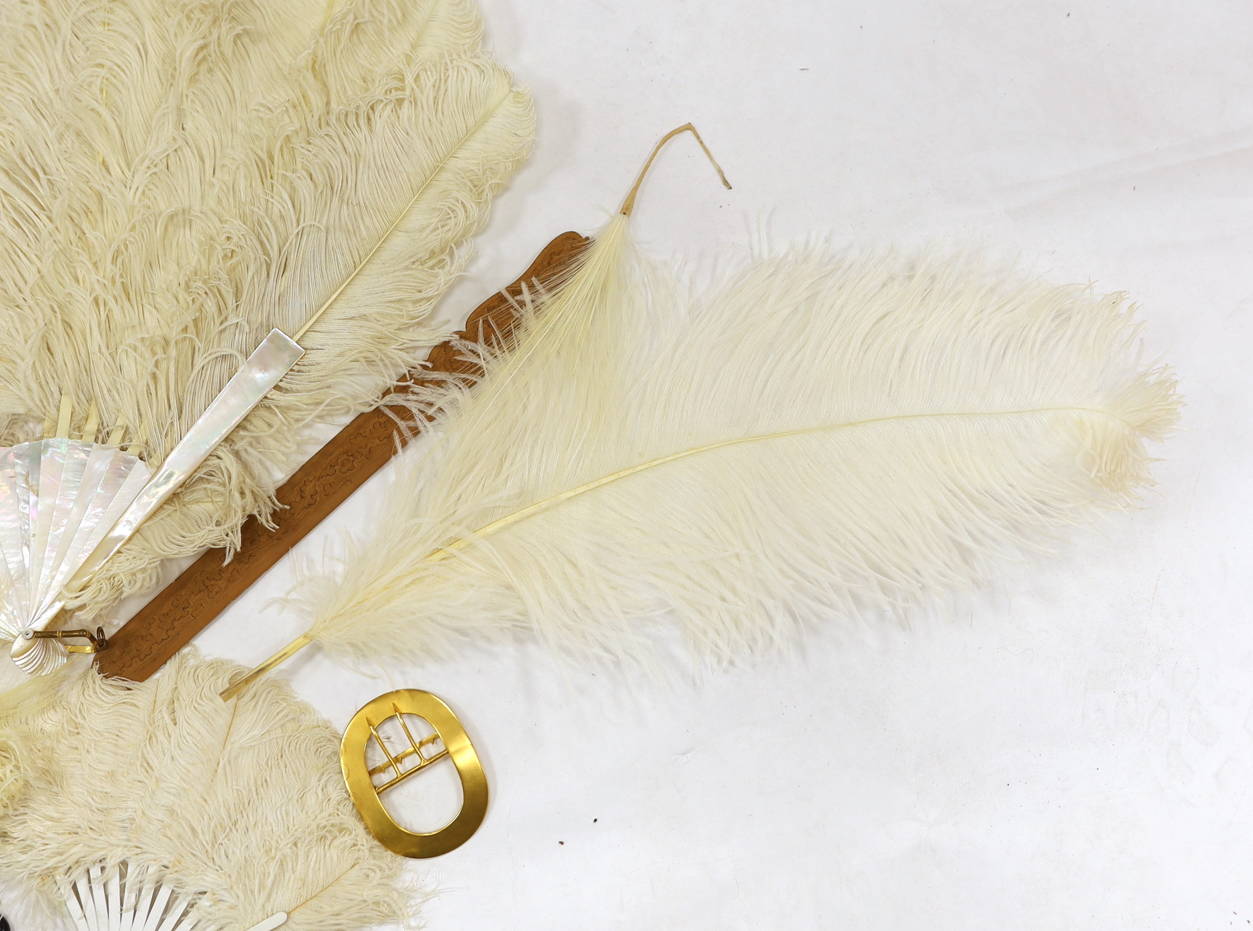 A Regency sequin and horn fan, a bone brise fan, a large white feather fan and a similar miniature fan and hat ornament two hair combs, etc
